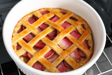 Photo of Baking dish with tasty apple pie in open oven, closeup