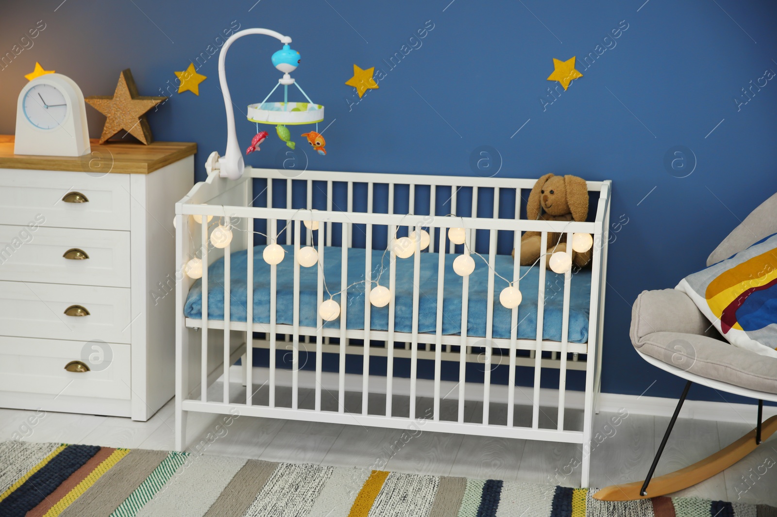 Photo of Baby room interior with comfortable crib and rocking chair