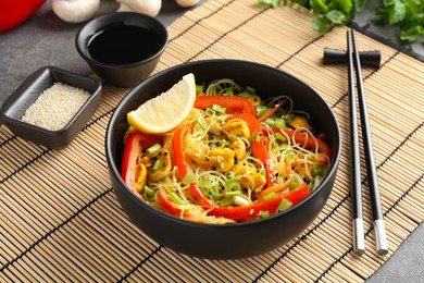 Photo of Stir-fry. Delicious cooked noodles with chicken and vegetables in bowl served on table