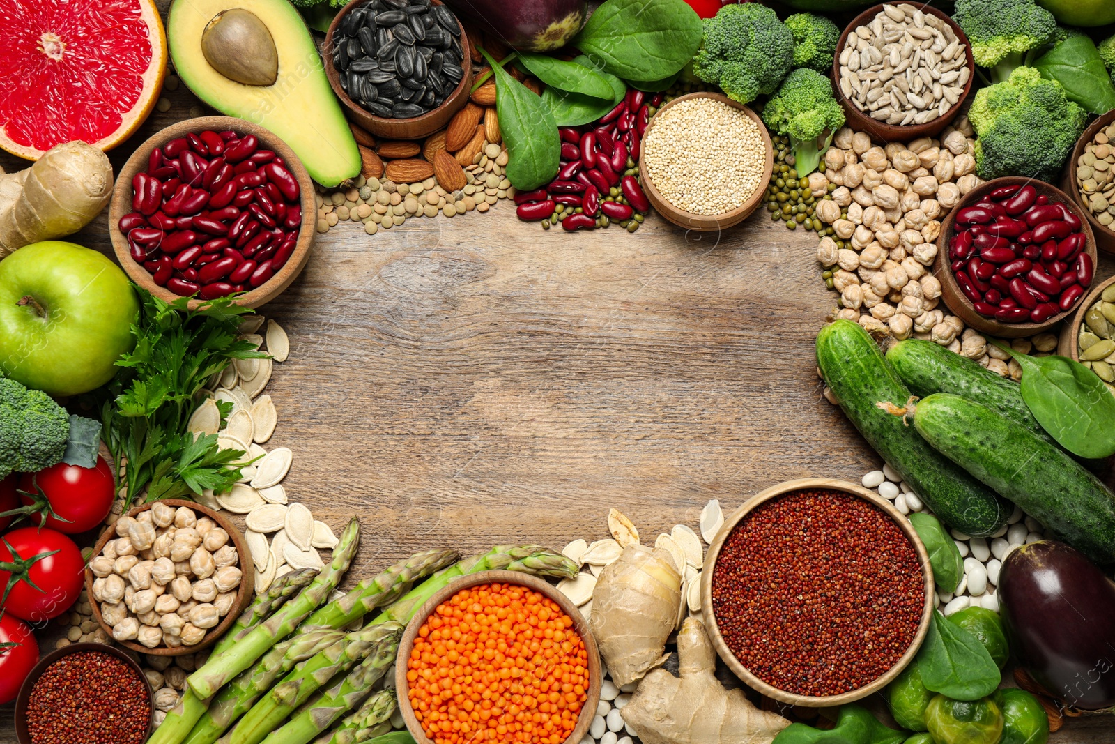 Photo of Frame made of different vegetables, seeds and fruits on wooden table, flat lay with space for text. Healthy diet