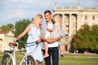 Photo of Happy family with bicycle outdoors on sunny day