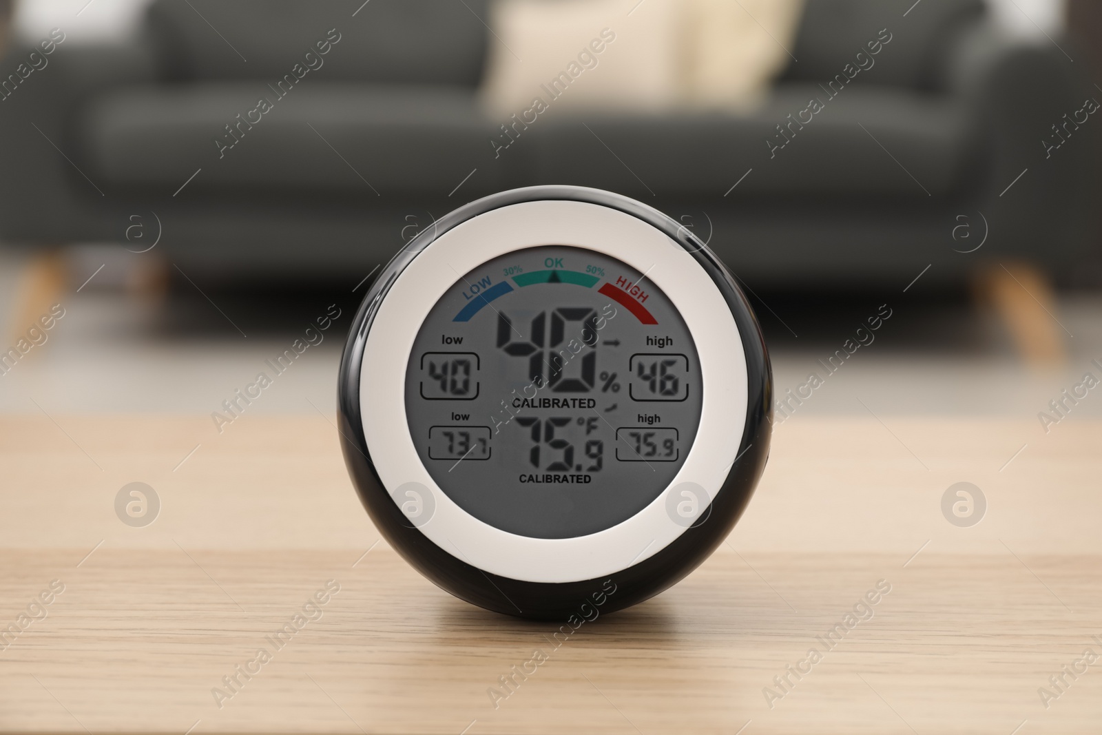 Photo of Digital hygrometer with thermometer on wooden table in room