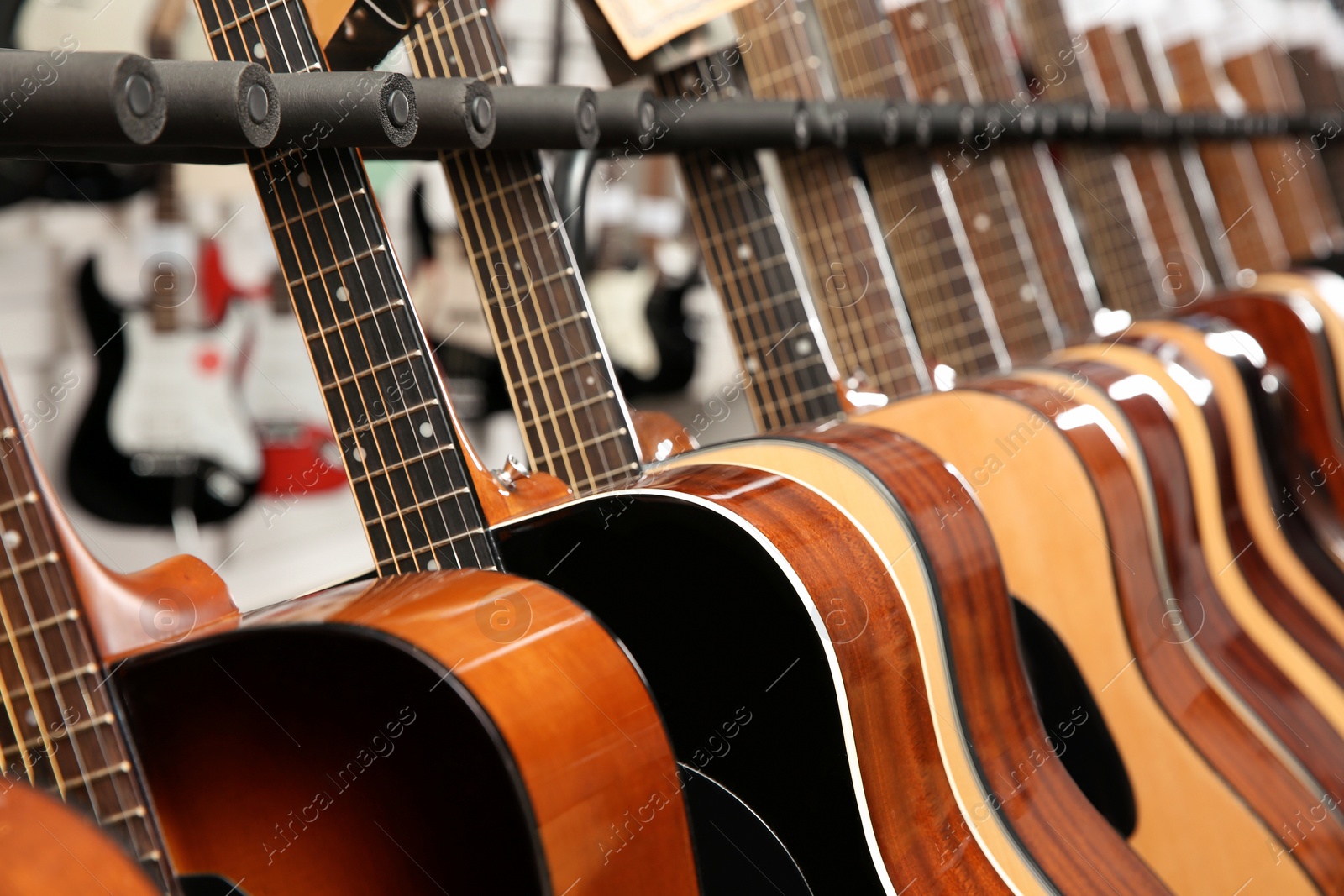 Photo of Row of different guitars in music store, closeup