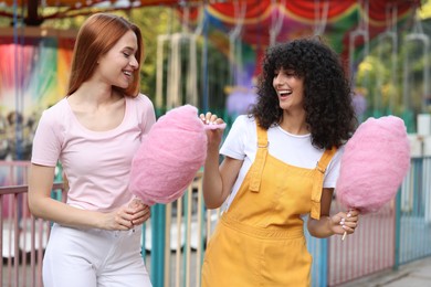 Photo of Happy friends with cotton candies spending time together at funfair