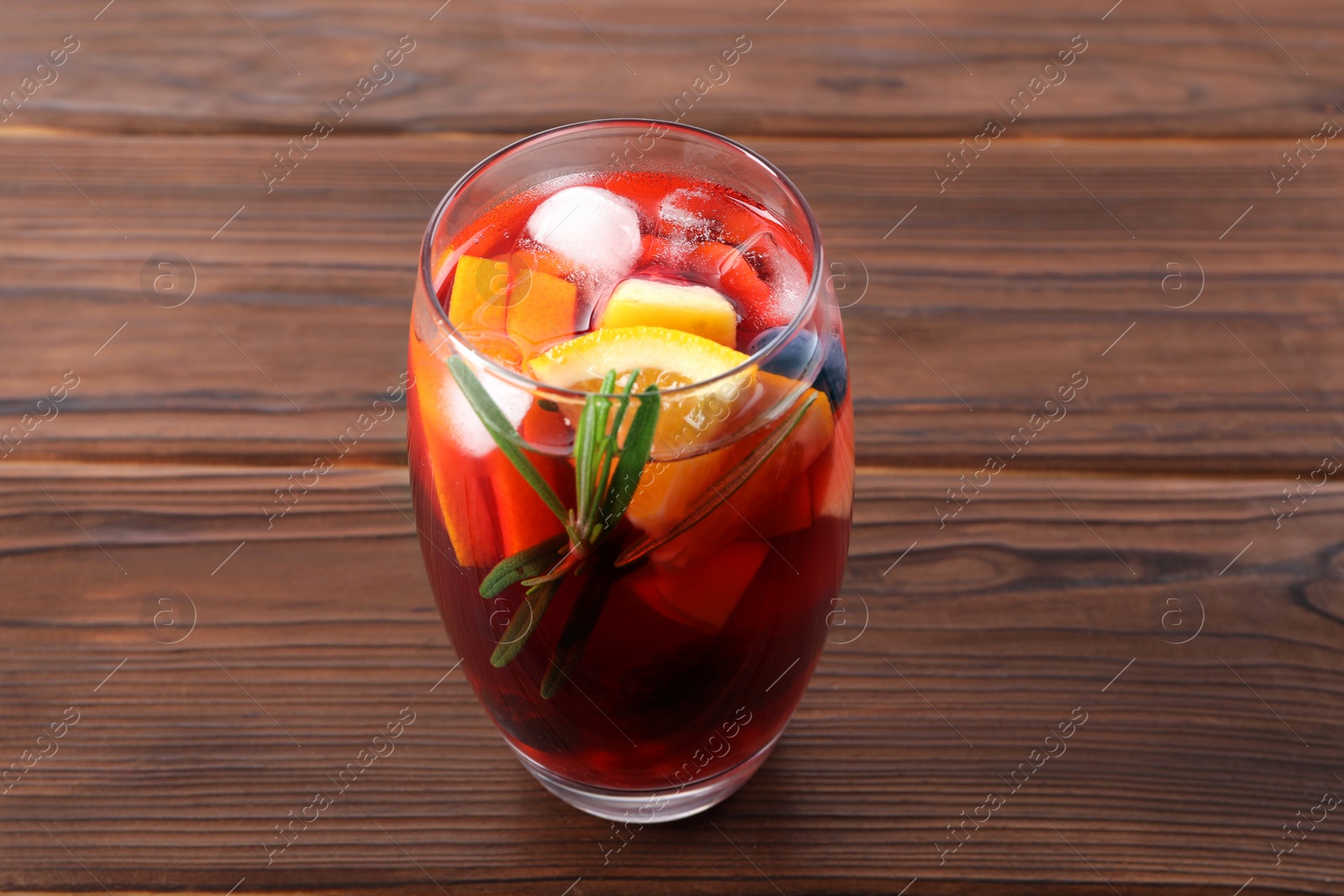 Photo of Glass of delicious sangria on wooden table