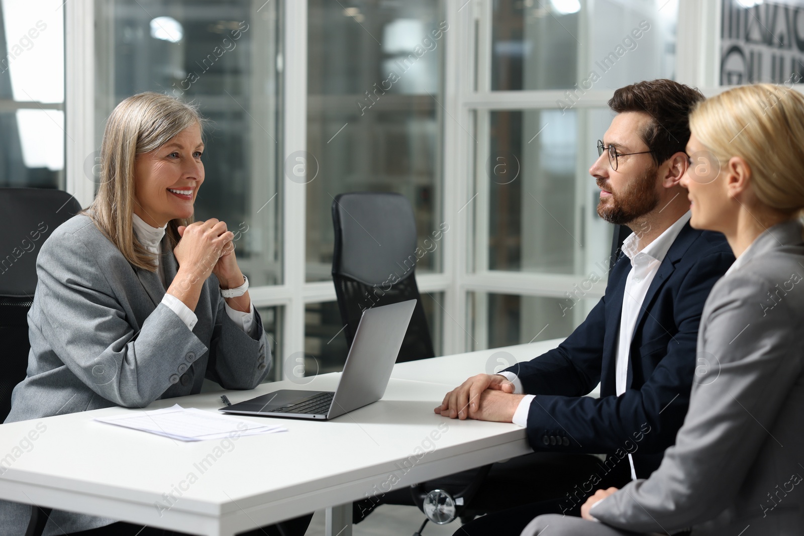 Photo of Lawyer working with clients at table in office