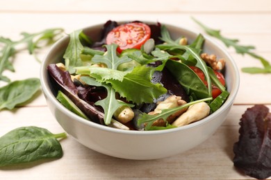 Tasty fresh vegetarian salad on light wooden table, closeup