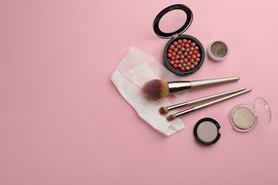 Photo of Dirty wet wipe, brushes and cosmetic on light pink background, flat lay. Space for text