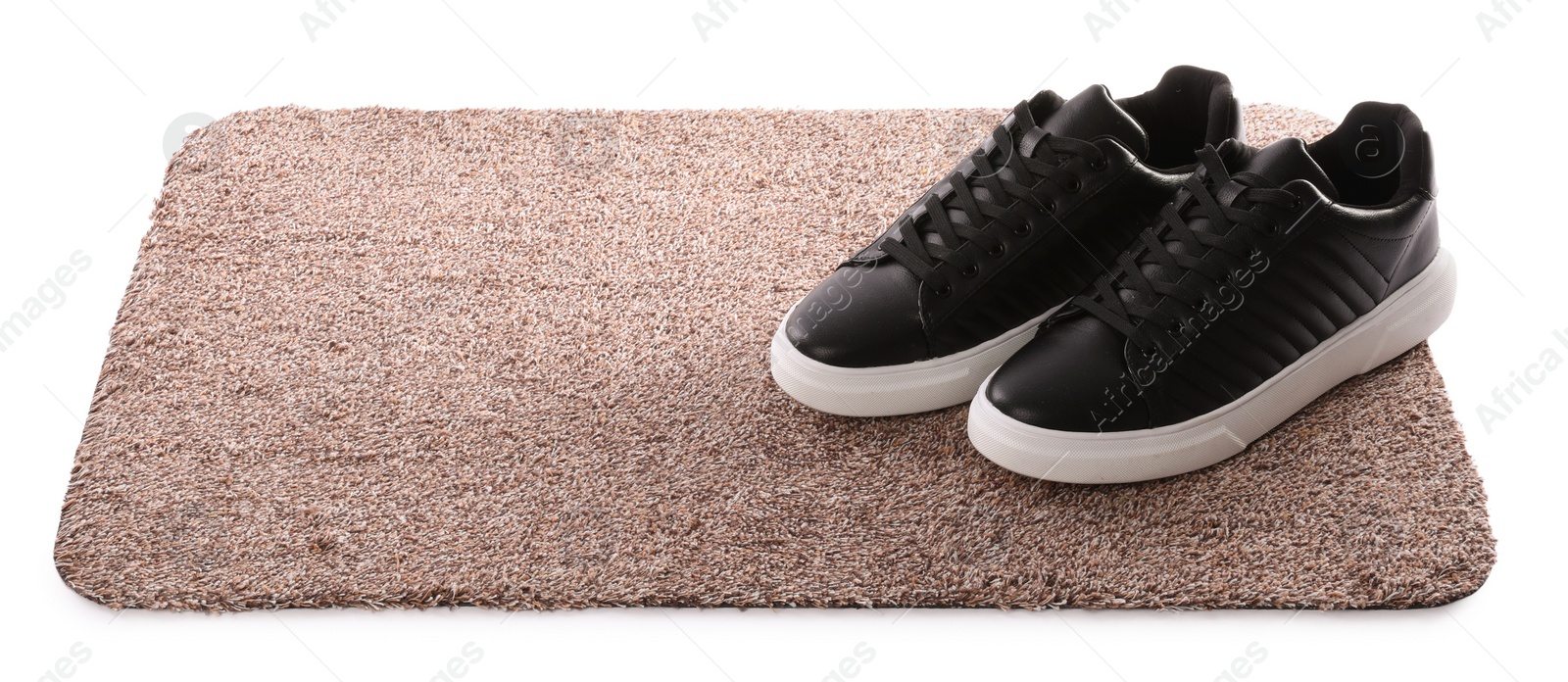 Photo of Stylish door mat with shoes on white background