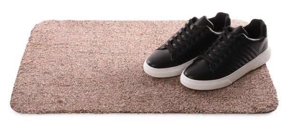 Stylish door mat with shoes on white background