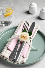 Beautiful table setting with fabric napkin and rose, closeup