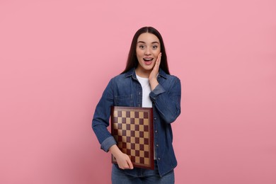 Photo of Happy woman with chessboard on pink background