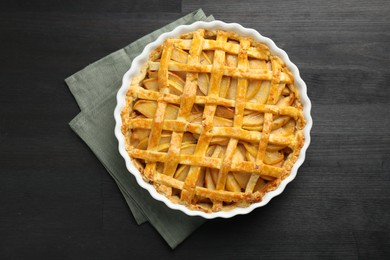 Photo of Tasty homemade quince pie on black wooden table, top view
