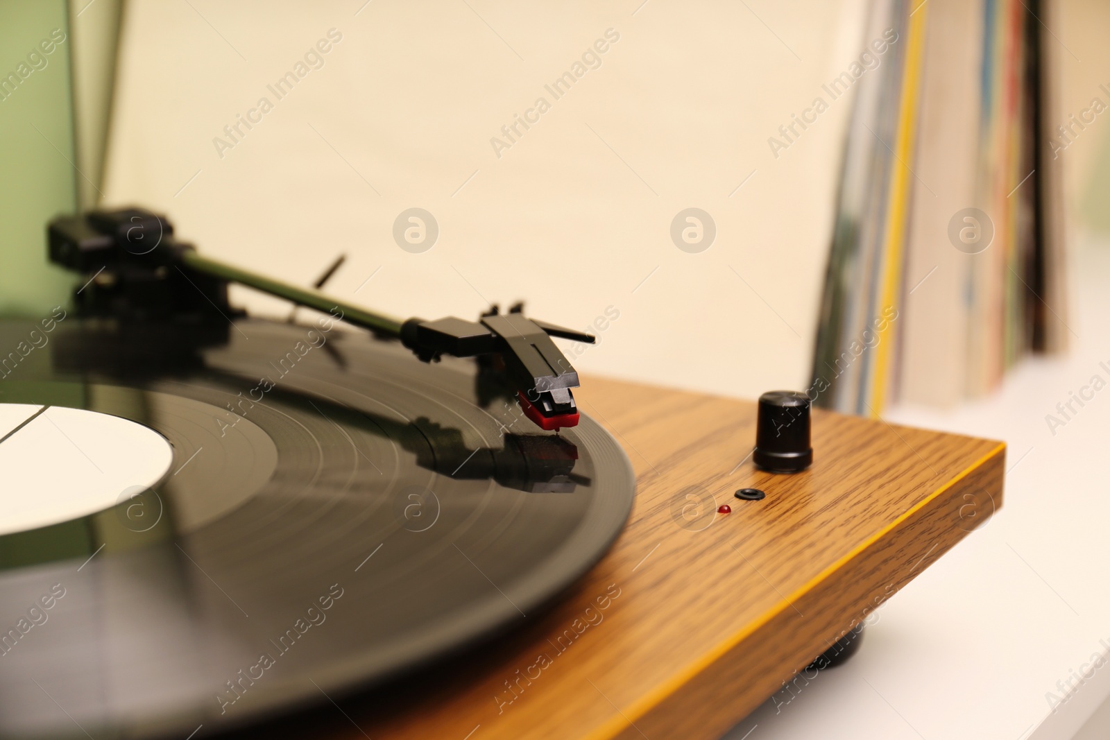 Photo of Turntable with vinyl record on white table, closeup. Space for text