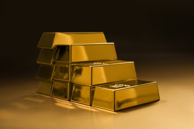 Photo of Stack of shiny gold bars on color background