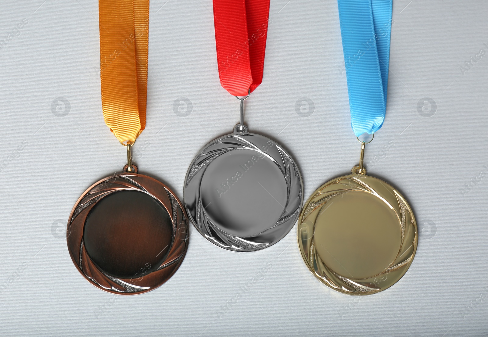 Photo of Gold, silver and bronze medals on white background, flat lay. Space for design