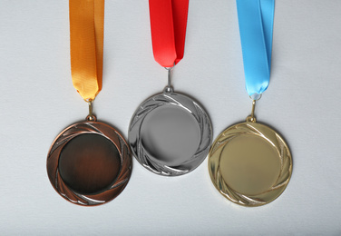 Photo of Gold, silver and bronze medals on white background, flat lay. Space for design