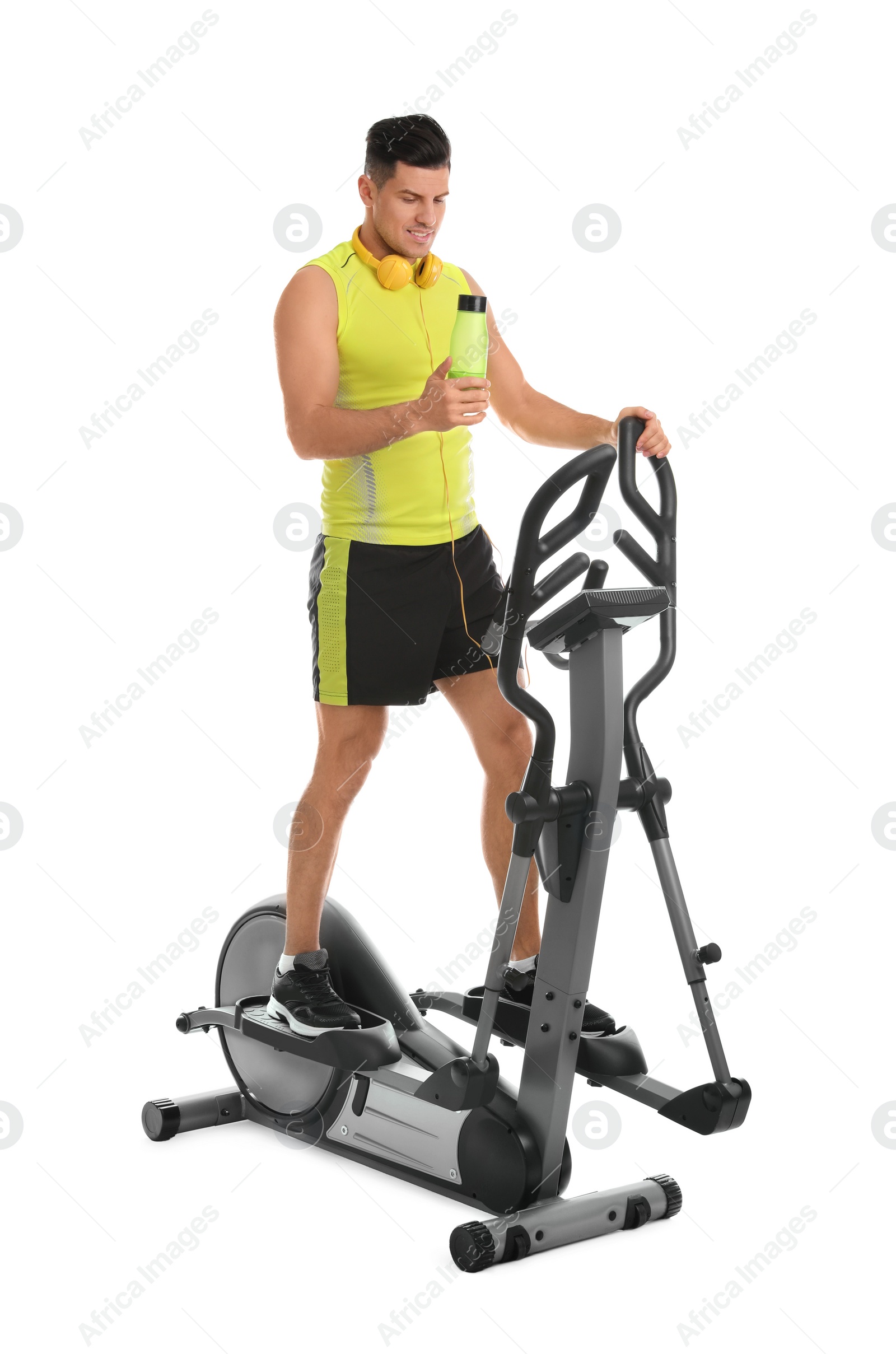 Photo of Man with bottle on modern elliptical machine against white background