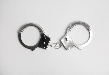 Photo of Classic chain handcuffs on white background, top view