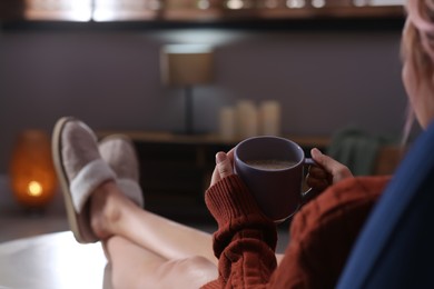 Woman with cup of aromatic coffee relaxing at home, closeup. Space for text