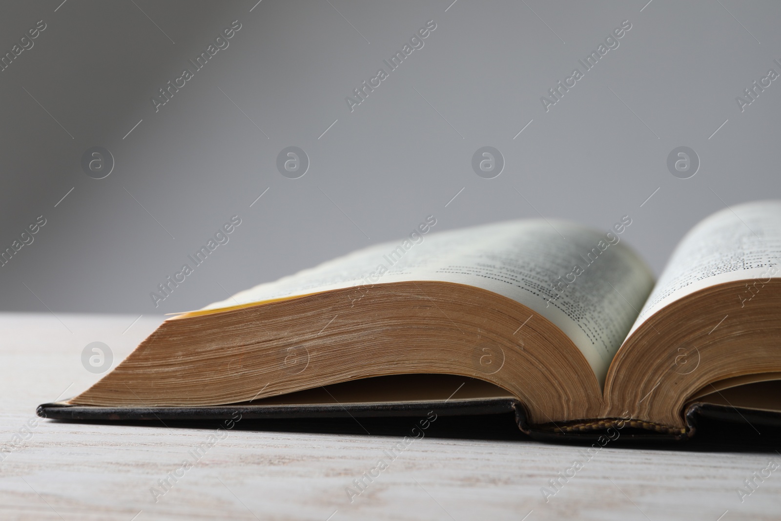 Photo of Open Bible on wooden table, closeup. Christian religious book