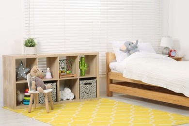 Photo of Stylish children room with comfortable bed and toys. Interior design