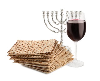 Photo of Traditional matzos, red wine and menorah on white background