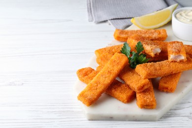 Photo of Tasty fresh fish fingers served on white wooden table, space for text