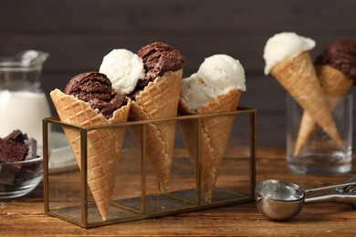 Photo of Tasty ice cream scoops in waffle cones on wooden table, closeup