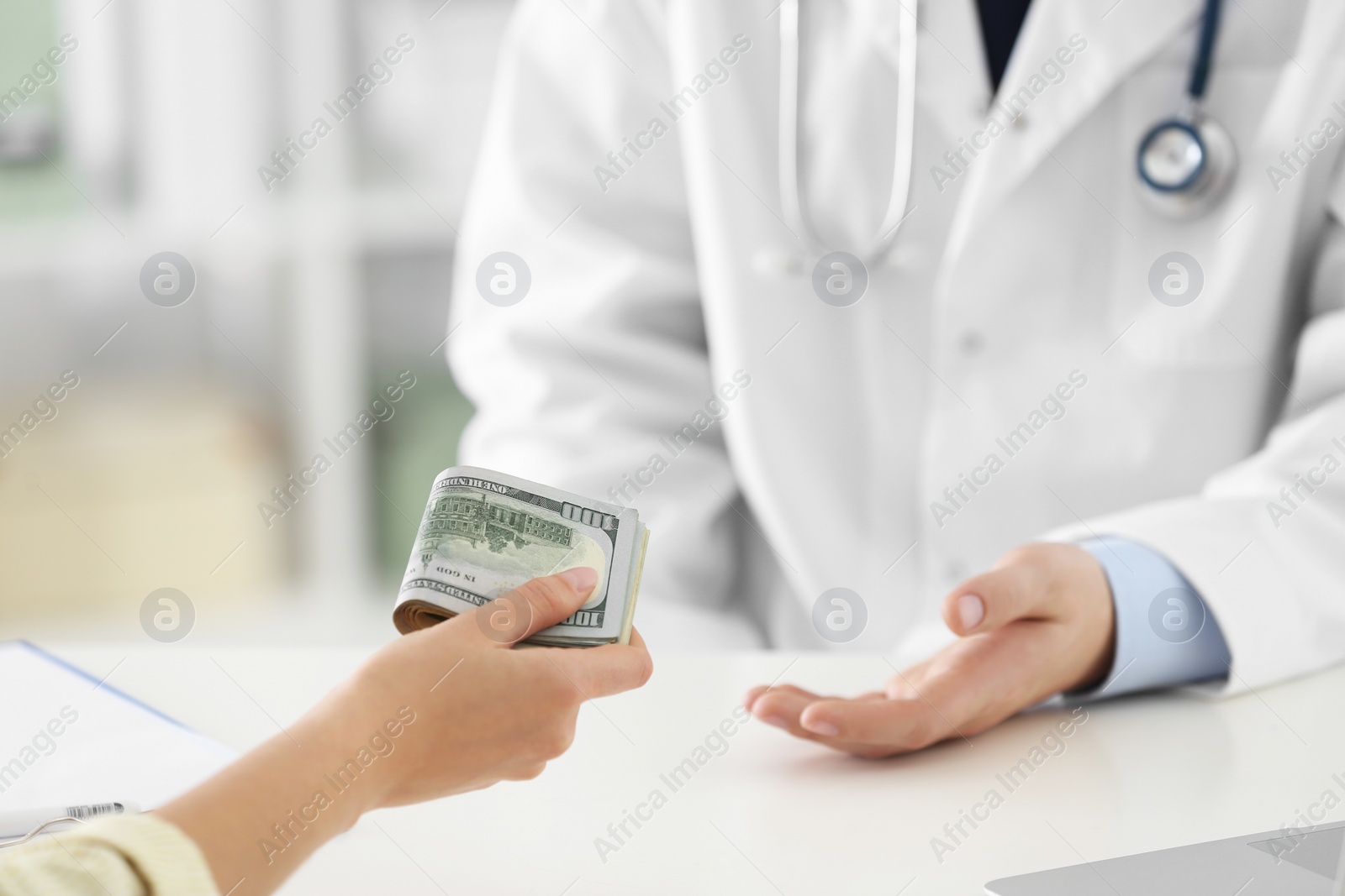 Photo of Patient giving bribe to doctor in clinic, closeup. Corrupted medicine