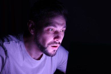 Photo of Man using computer at night. Internet addiction