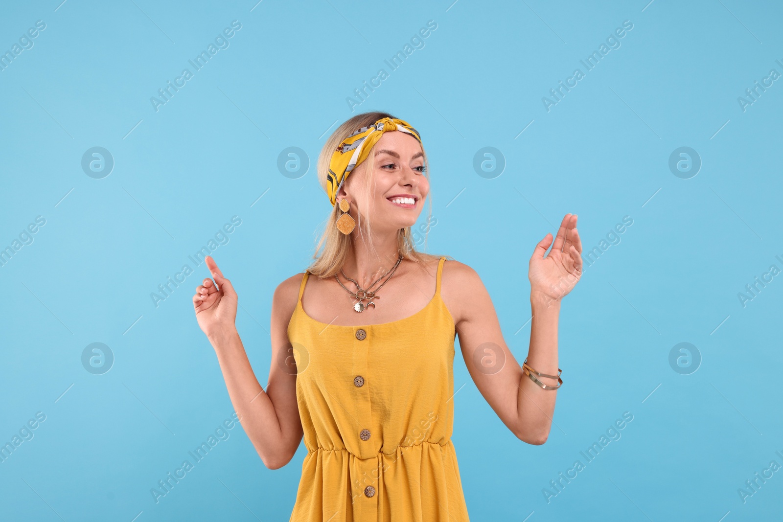 Photo of Portrait of happy hippie woman on light blue background