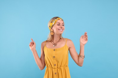 Portrait of happy hippie woman on light blue background