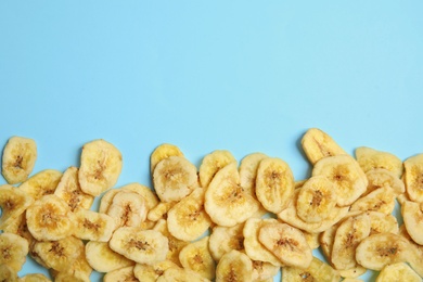 Tasty banana slices on color background, top view with space for text. Dried fruit as healthy snack