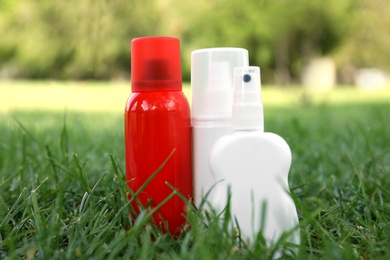 Bottles of insect repellent on green grass