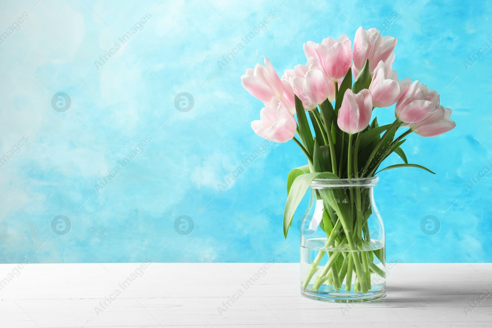 Photo of Vase with beautiful tulips for Mother's Day on table