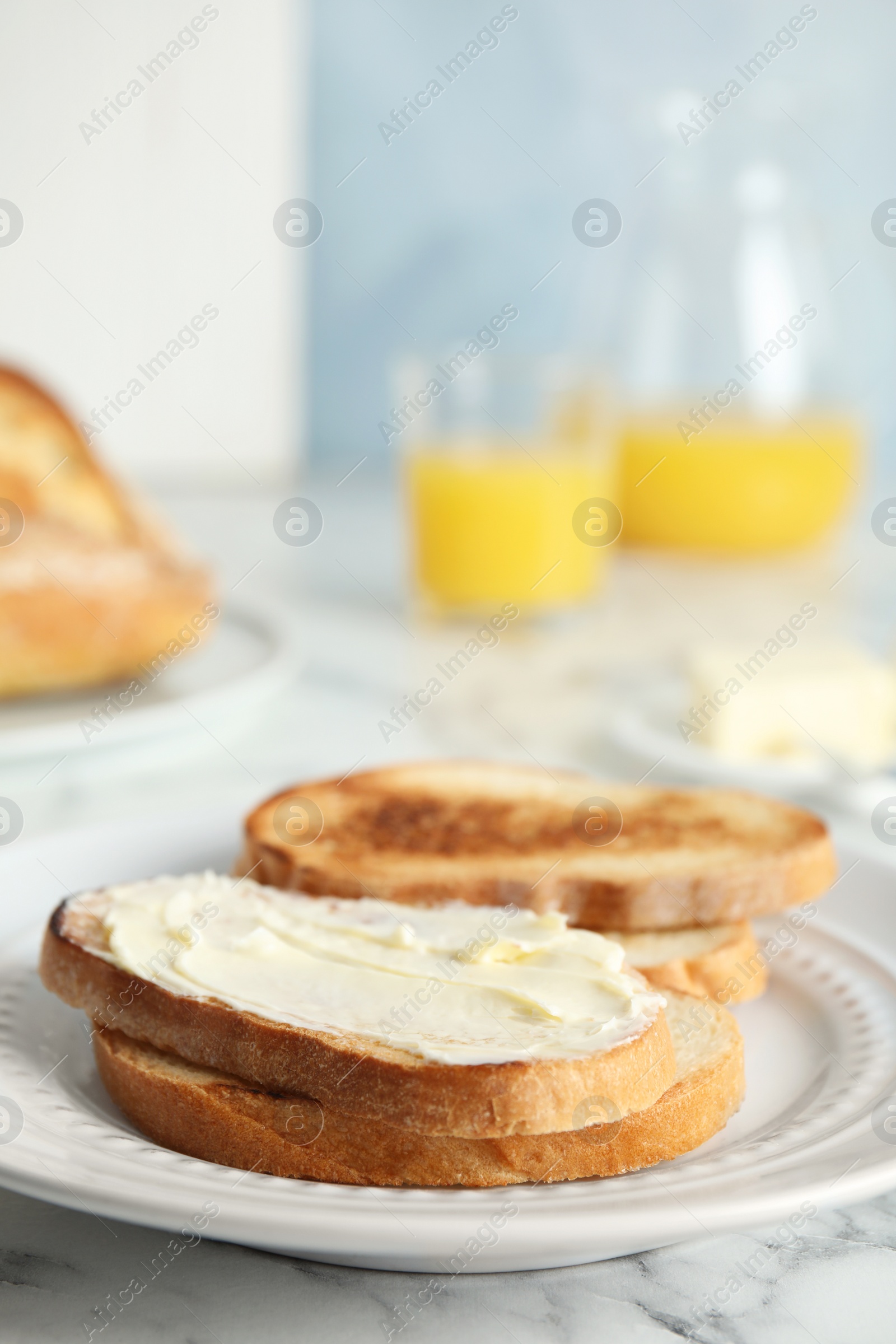 Photo of Tasty bread with butter served for breakfast on marble table. Space for text