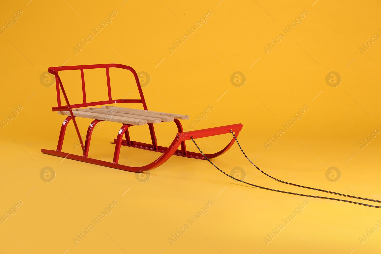 Photo of Stylish sleigh on yellow background. Winter activity