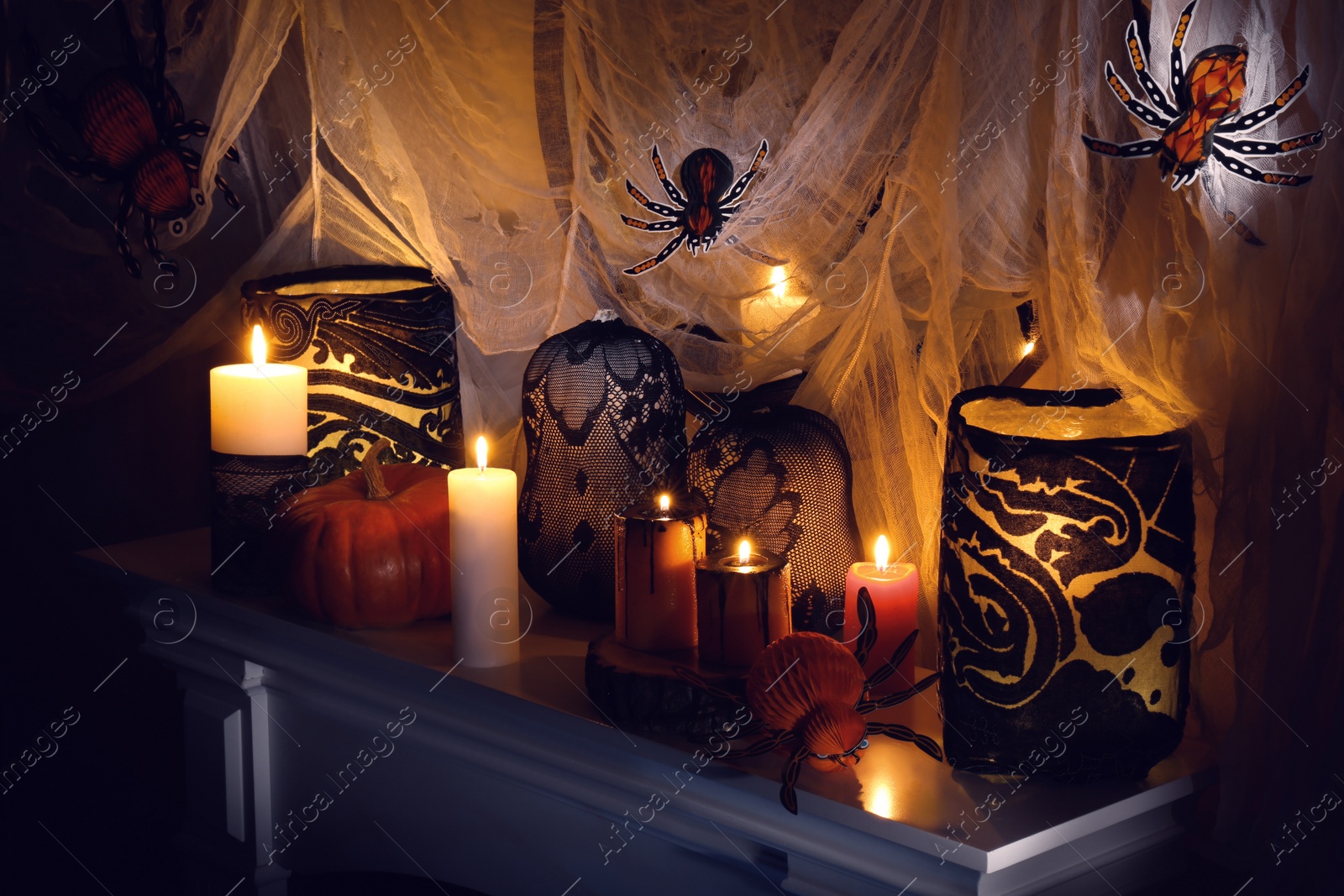 Photo of Different Halloween decor on fireplace indoors. Festive interior