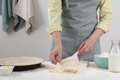 Making tasty baklava. Woman with dough at table, closeup and space for text