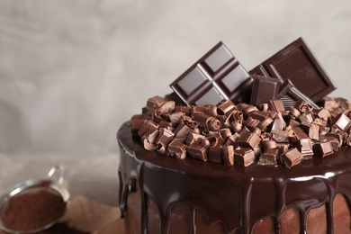 Photo of Freshly made delicious chocolate cake against grey background, closeup. Space for text