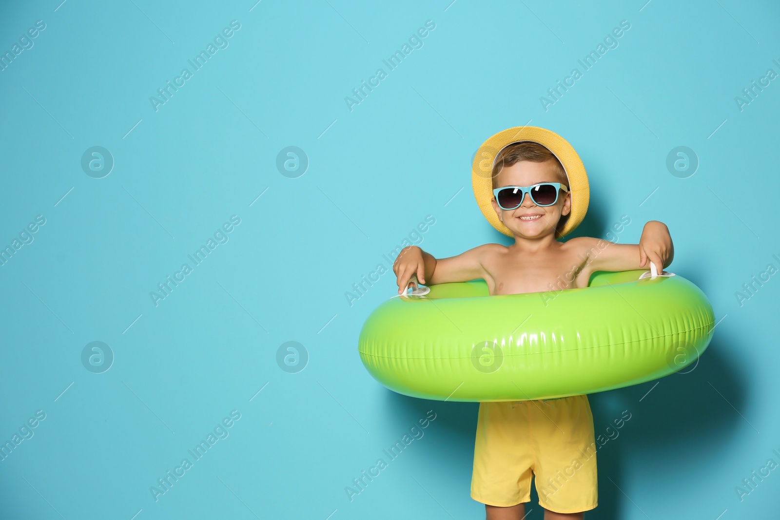 Photo of Cute little boy with inflatable ring on color background