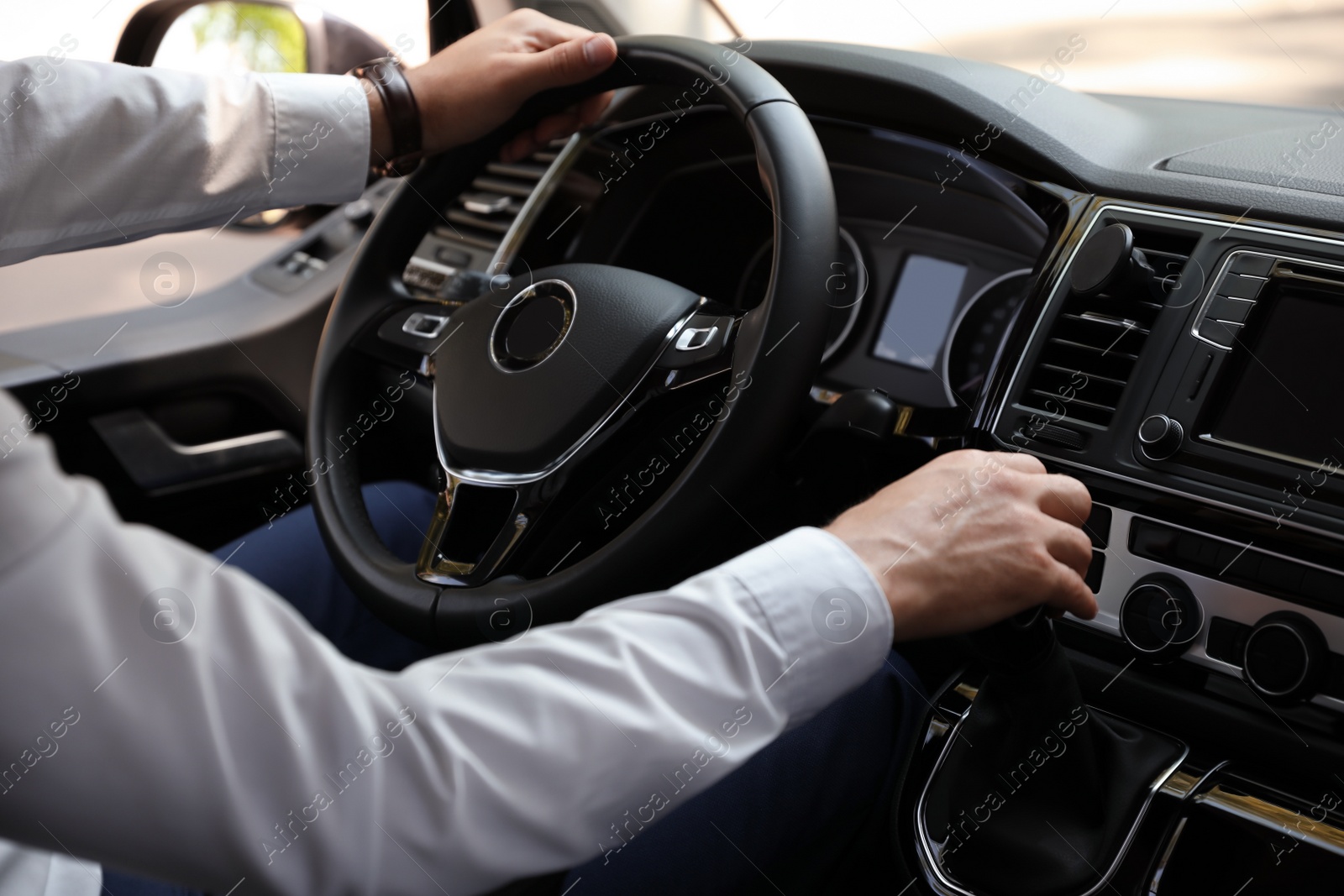 Photo of Man driving his car, closeup view of hands on steering wheel