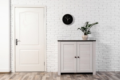 Photo of Light room interior with white door in brick wall