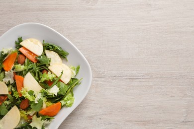 Photo of Delicious turnip salad served on wooden table, top view. Space for text