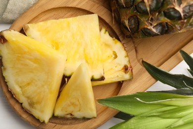 Photo of Slices of ripe juicy pineapple on white table, top view