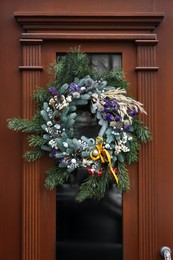 Beautiful Christmas wreath hanging on wooden door