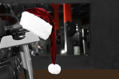 Santa hat on stand with dumbbells in modern gym