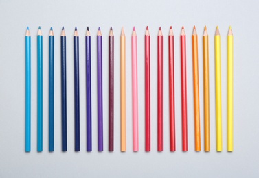 Photo of Colorful pencils on light background, flat lay