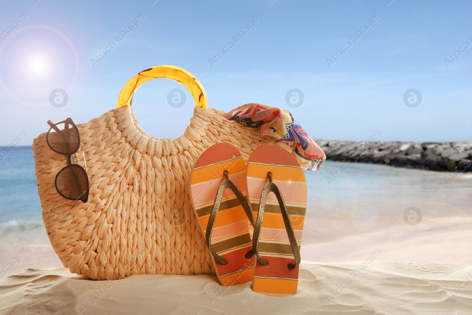 Image of Different beach accessories on sand near sea